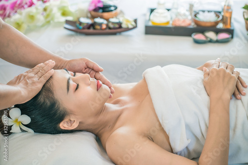 spa,wellness, beauty and relaxation concept -Young Asian woman receiving head massage at beauty spa