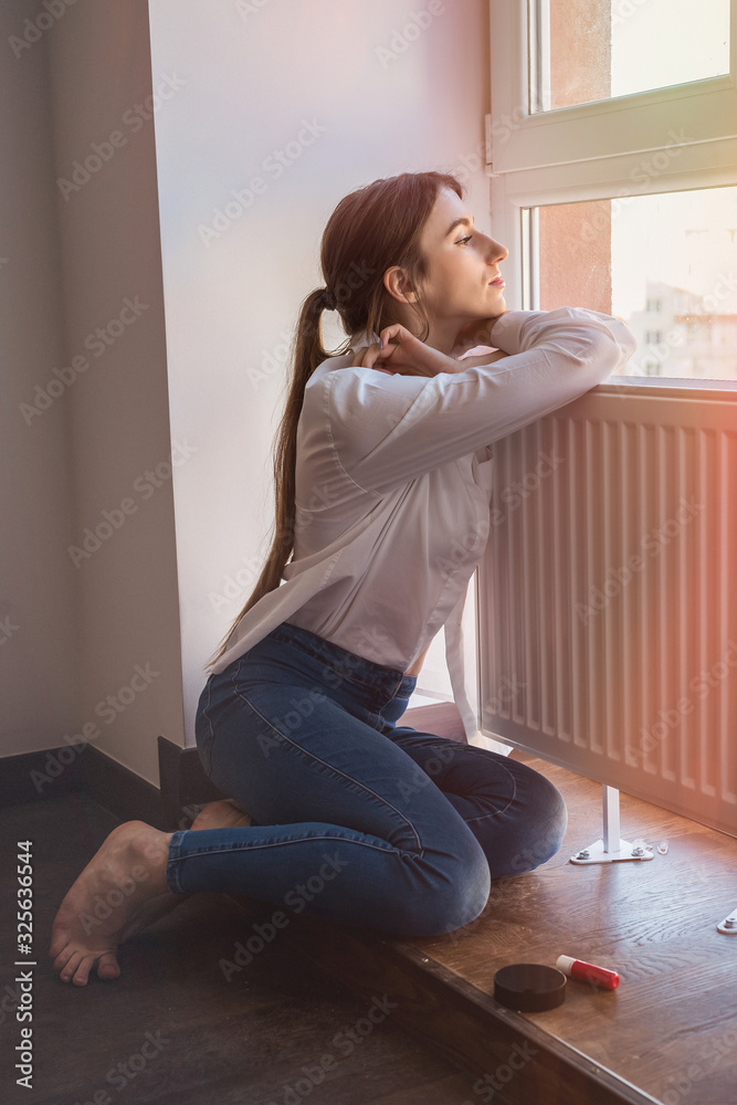 beautiful girl posing by the window, enjoying the sunshine. beautiful girl posing by the window, enjoying the sunshine.