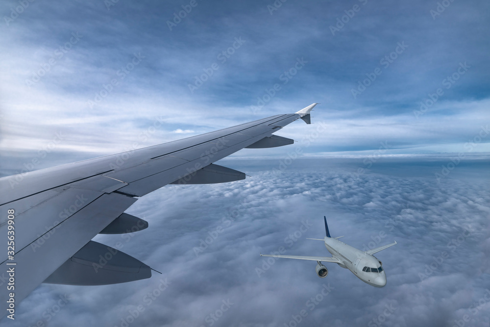 Obraz premium Wing of jet and airplane fly in sky above clouds. View from plane window