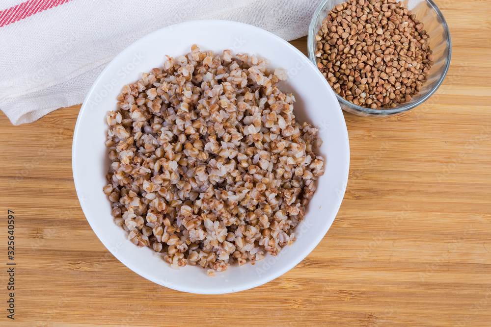 Top view of prepared buckwheat porridge and uncooked buckwheat groat Top view of prepared buckwheat porridge and uncooked buckwheat groat