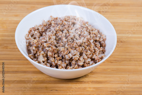 Freshly prepared buckwheat porridge in white bowl close-up