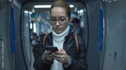 Woman on a subway train looking at a smartphone