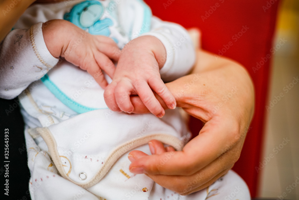 Obraz premium Main de bébé tenant le pouce de sa mère