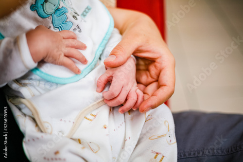 Mère tenant la main de son bébé