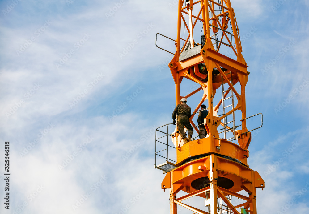 Ouvrier travaillant sur une grue de construction Ouvrier travaillant sur une grue de construction