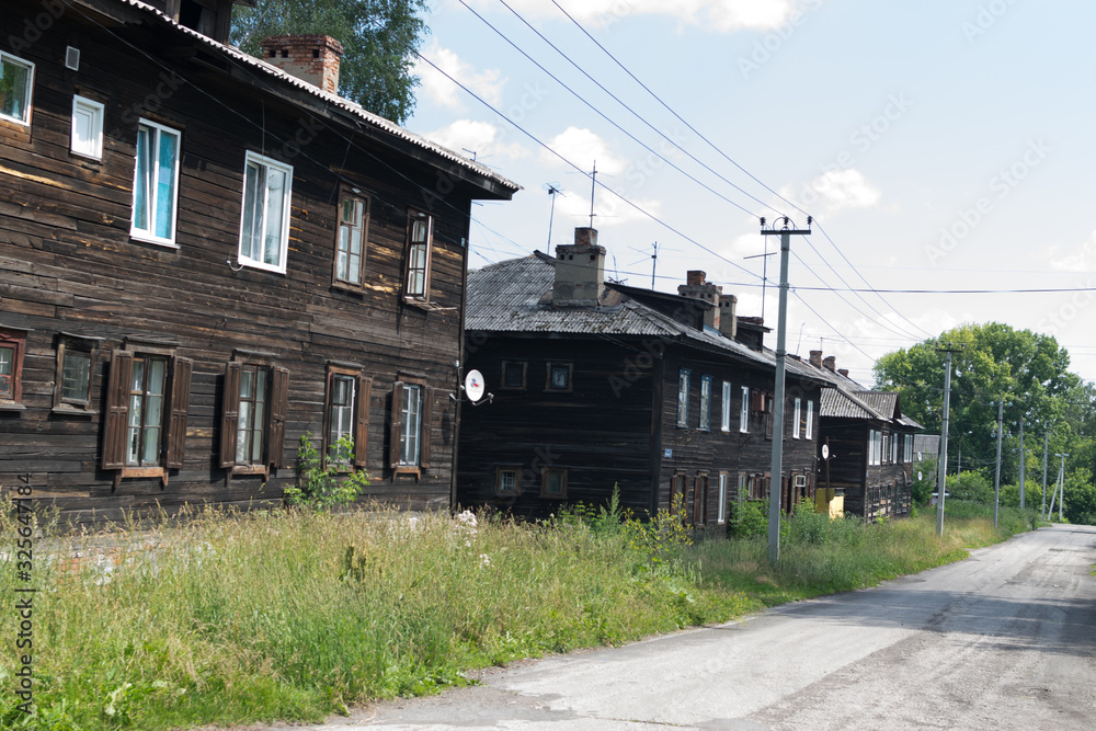 Old overgrown street in Prokopievsk with wooden houses