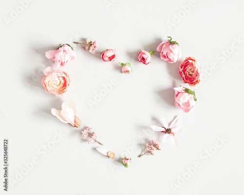 Flowers composition. Heart made of pink flowers on pastel gray background. Valentines day, mothers day, womens day concept. Flat lay, top view