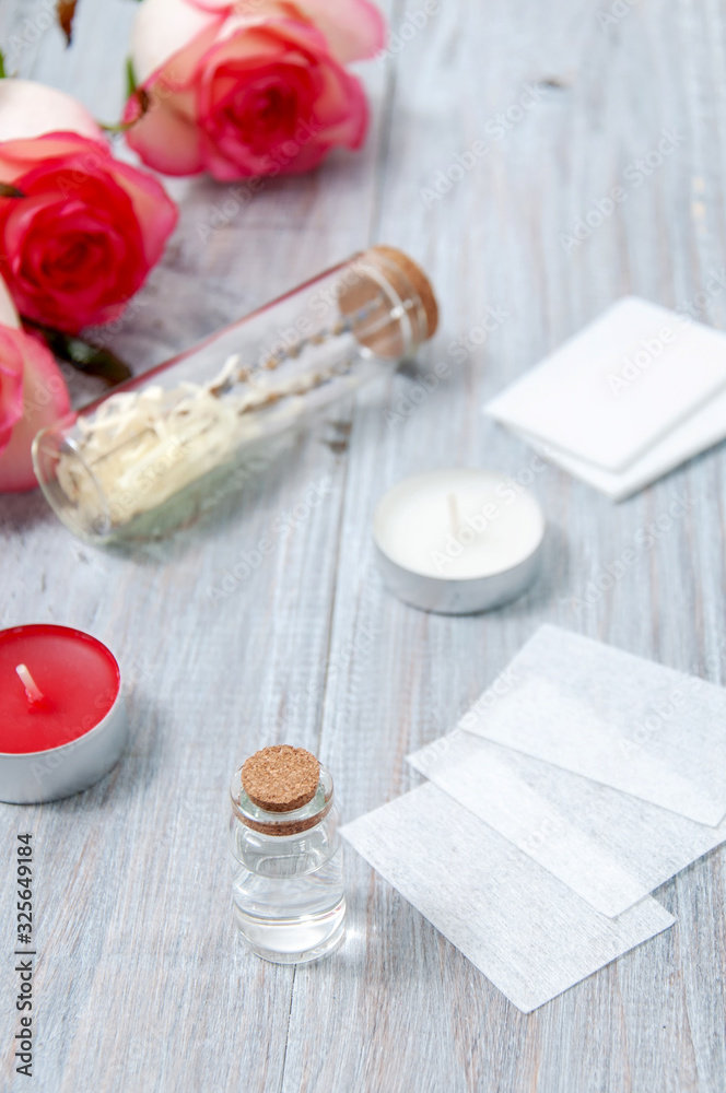 Pink roses, oil bottles and candles on a gray wooden table. March 8. Valentine's Day. Greeting card. Romantic and beautiful background. Spa treatments. Personal care. Love and beauty. Pink roses, oil bottles and candles on a gray wooden table. March 8. Valentine's Day. Greeting card. Romantic and beautiful background. Spa treatments. Personal care. Love and beauty.
