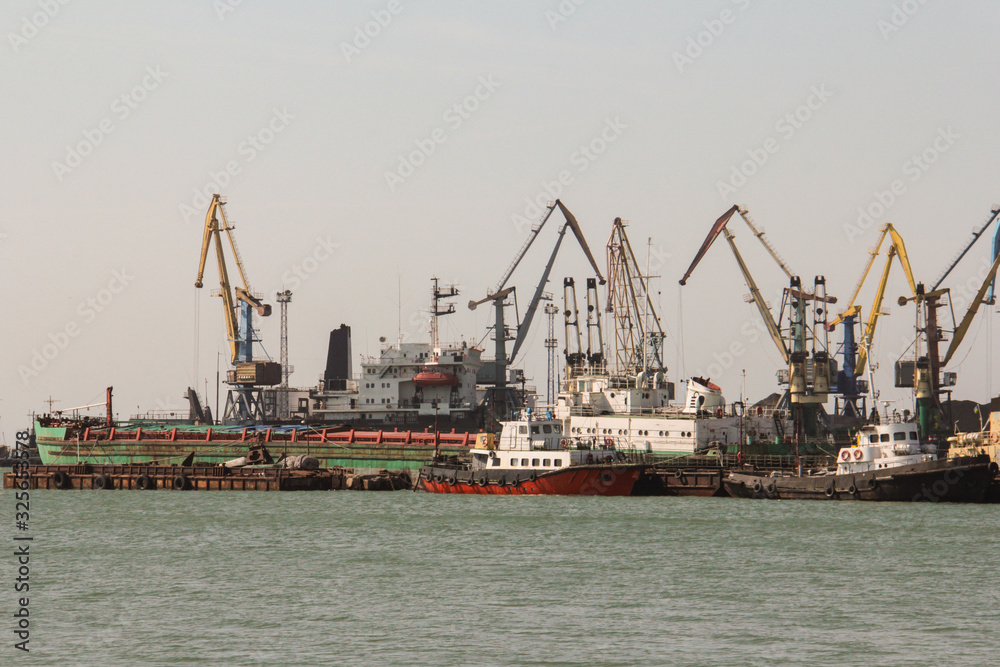 Cargo port, ships cranes in the sea bay