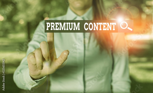 Writing note showing Premium Content. Business concept for higher quality or more desirable than free content Woman in a blue shirt pointing with her finger into empty space