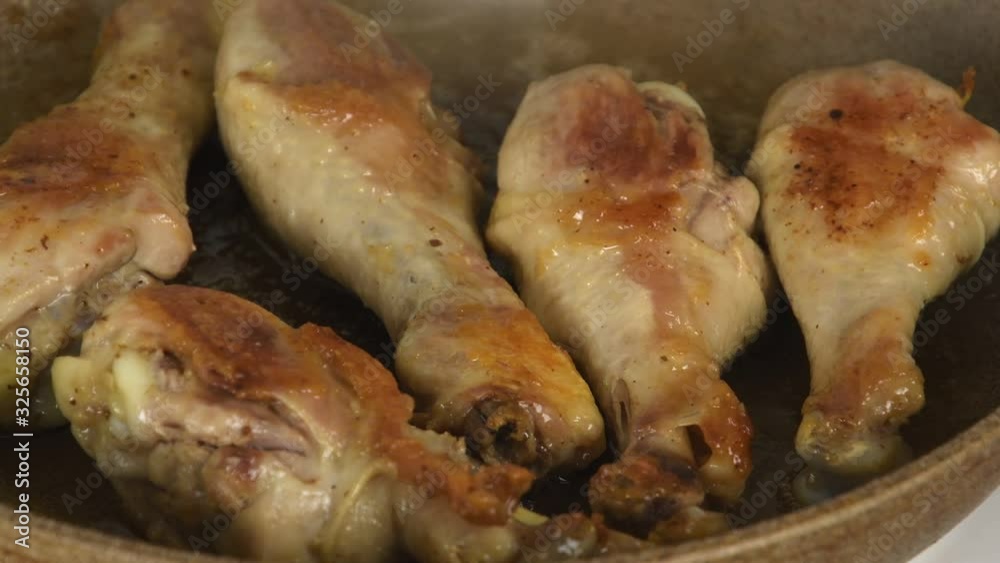 Shaking the fried chicken legs in a skillet and cover with a lid Shaking the fried chicken legs in a skillet and cover with a lid