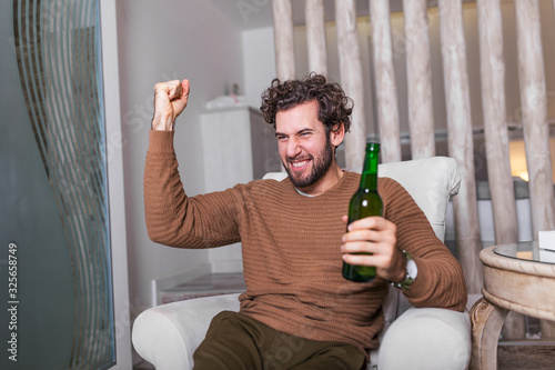 Cuadro en lienzo Fanatic sports fan man watching soccer game on tv celebrating