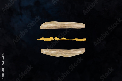 Layers of cheeseburger on black background