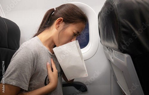 Foto female passenger on the plane felt airsick, affected with nausea due to travel i