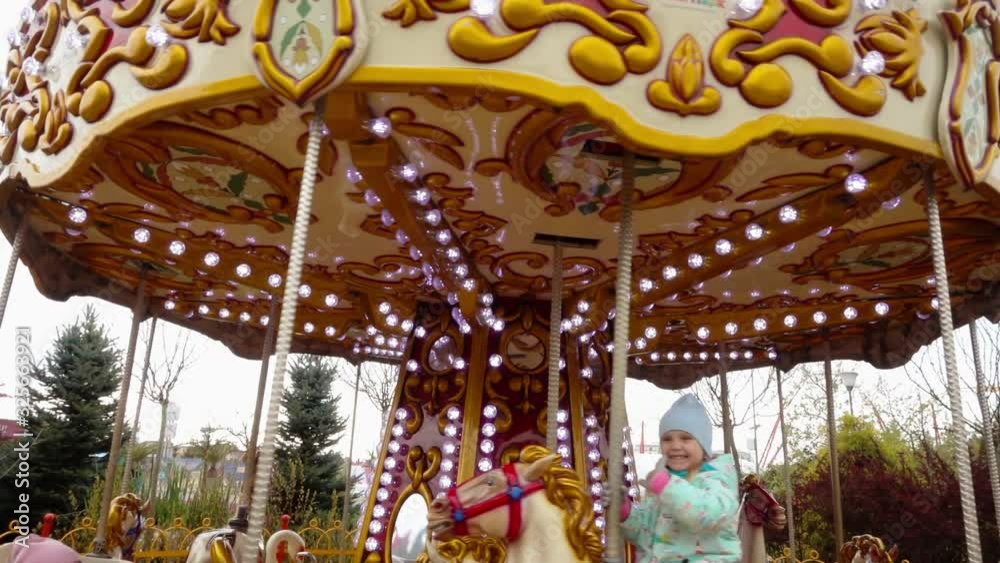 Children ride on an amusement park carousel Children ride on an amusement park carousel