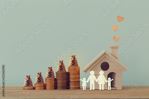 Mini house and heart, family members, US money bags on rows of rising coins on table. Family tax benefit, residential property tax concept: depicts home equity loan, real estate business investment.