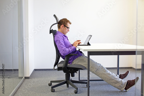 various positions sitting position at the office desk . man on chair working with tablet