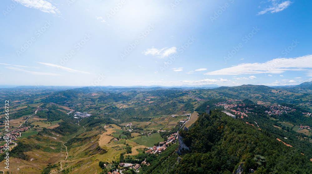 Obraz premium Aerial view on Third, distant tower on top of the mountain. Fortifications, in the background mountains and the city. The concept of wide panorama wallpaper Europe. San Marino, Italy