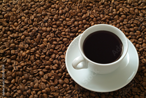 Cup of coffee on coffee beans