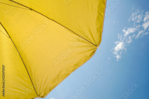  yellow umbrella on blue sky with clouds. Happy holiday vacation concept