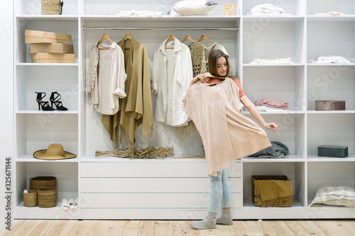Photos Young adult woman standing near wardrobe,  choosing wear