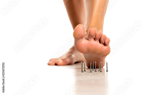 a woman's foot stepped on nails on white © vladimirfloyd