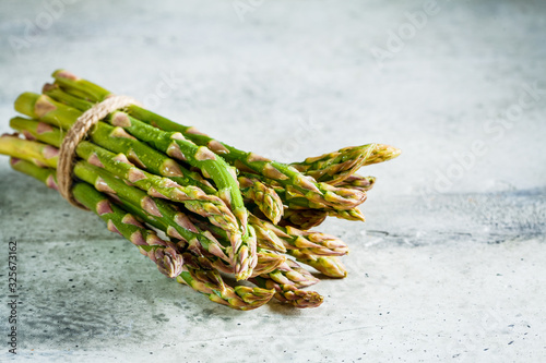 Fresh green asparagus on gray background. Healthy vegan food concept.