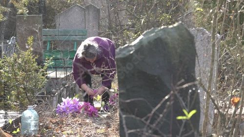 Elderly woman visiting grave in a cemetery. Abdal Cemetery in Simferopol. photo