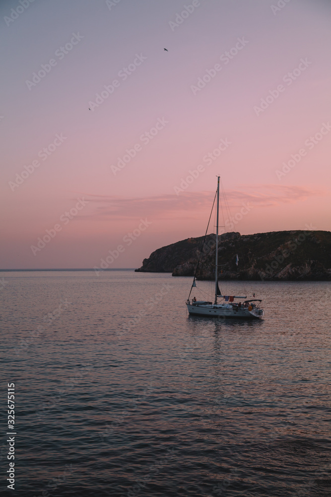 Sailing boat/yacht on the evening time at sunset. Pink and purple sky. Majorca, Balearic Islands. Travel and vacation concept. 