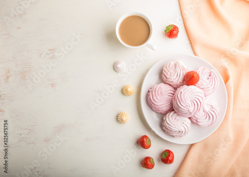 Pink strawberry homemade zephyr or marshmallow with cup of coffee on white wooden background. top view, copy space.