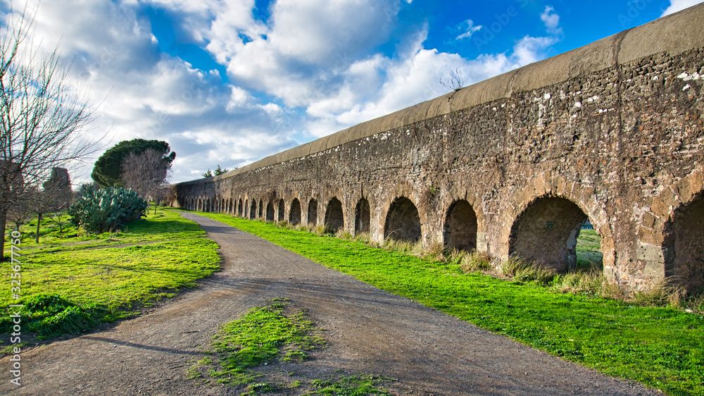 Ruin of the roman ancient Aqueduct in Rome whit cloud sky in the background.