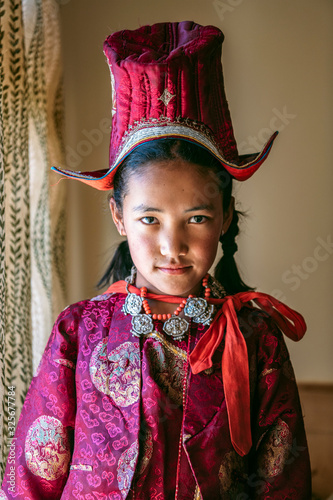 Portrait of a beautiful young girl in typical tibetan clothes with hat in Ladakh, Kashmir, India