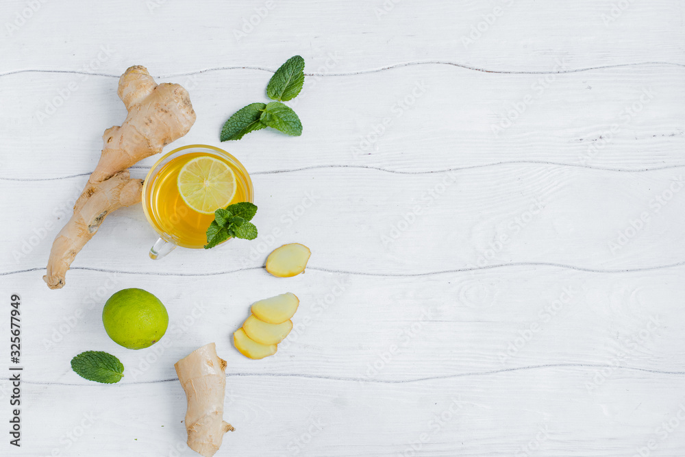 Ginger with lime and a Cup of tea on a wooden table top view copy space