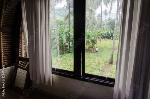 Vistas de la naturaleza a través de la ventana en un alojamiento de Bali