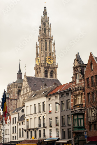 Vertical view of bell tower of Cathedral of Our Lady in Antwerp, UNESCO world heritage site in Belgium with flemish houses around. Popular travel tourism destination in Benelux