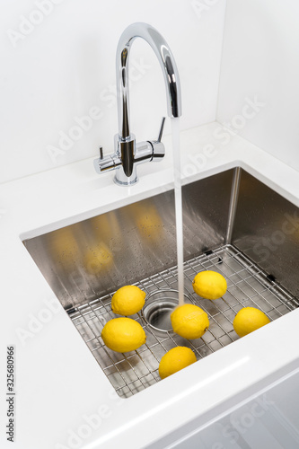 Washing lemons in the kitchen sink.