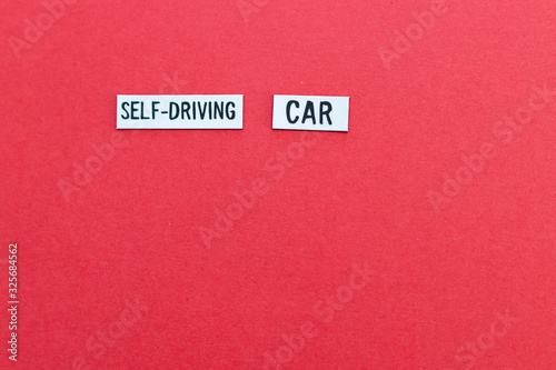 SELF DRIVING CAR text on label on red background. Autonomous driving background with copy space to write your personalized message. Automotive background with artificial intelligence