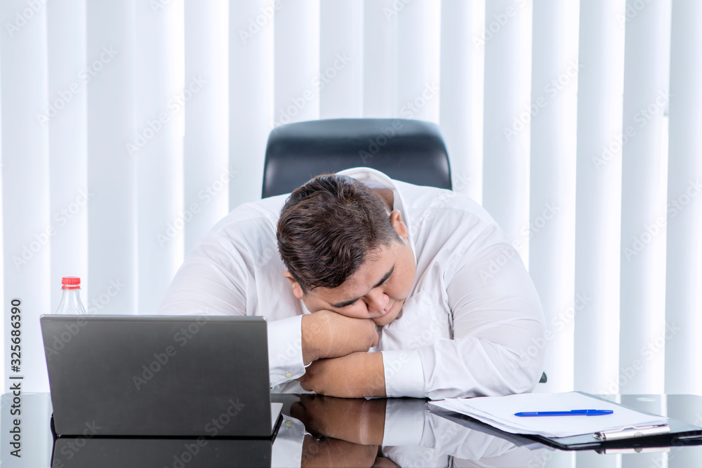 Fat Asian man sleeping while working in his office Fat Asian man sleeping while working in his office