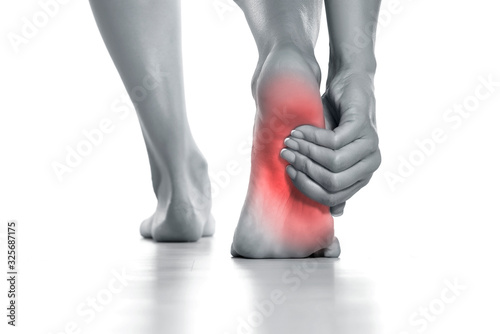 Billede på lærred woman holding her painful foot on white