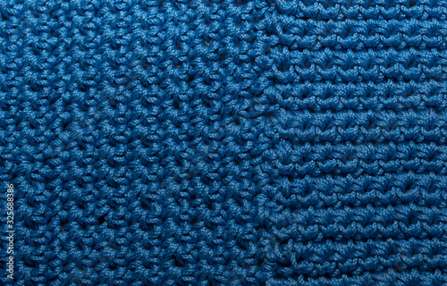 Knitted texture, front surface. Natural wool, classic blue, monochrome. Close-up, background