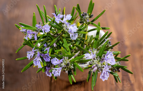 Fresh purple flowering rosemary on a rustic wooden background