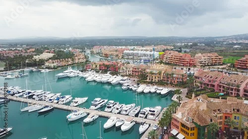 Unique generic aerial view of exclusive Sotogrande Bay - Costa del Sol. Cloudy day and rainy , beautiful sky colours. Luxury real estate and yacht. Famous location. 