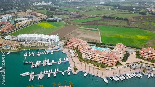 Unique generic aerial view of exclusive Sotogrande Bay - Costa del Sol. Cloudy day and rainy , beautiful sky colours. Luxury real estate and yacht. Famous location.  photo