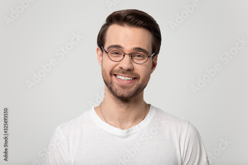 Young happy guy wearing glasses looking at camera portrait. © fizkes
