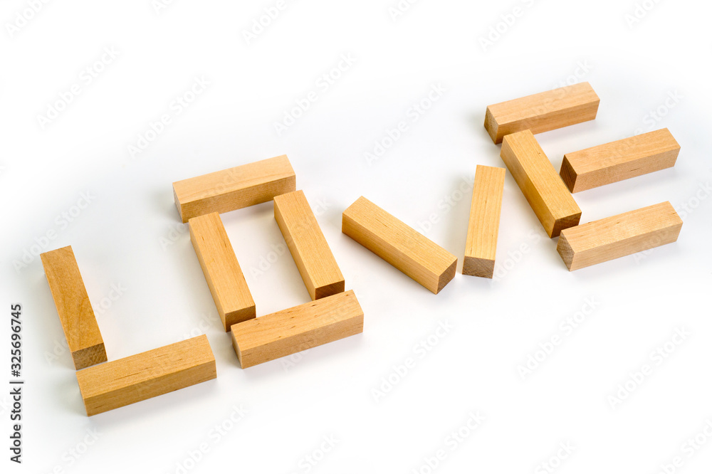 The word Love laid out by wooden blocks on a white background. Background for love and romance. The word Love laid out by wooden blocks on a white background. Background for love and romance.