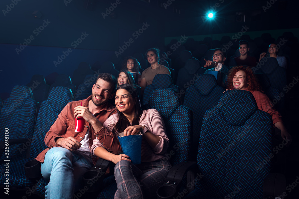 Group of cheerful people laughing while watching movie in cinema. Group of cheerful people laughing while watching movie in cinema.