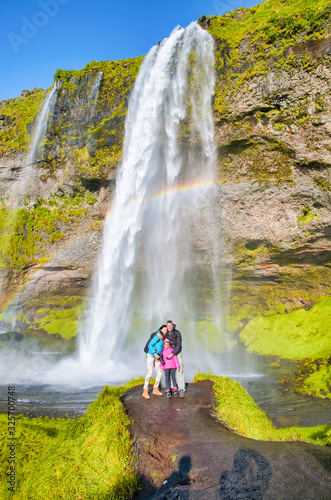 Happy family enjoying Seljalandsfoss Waterfall in summer season, Iceland