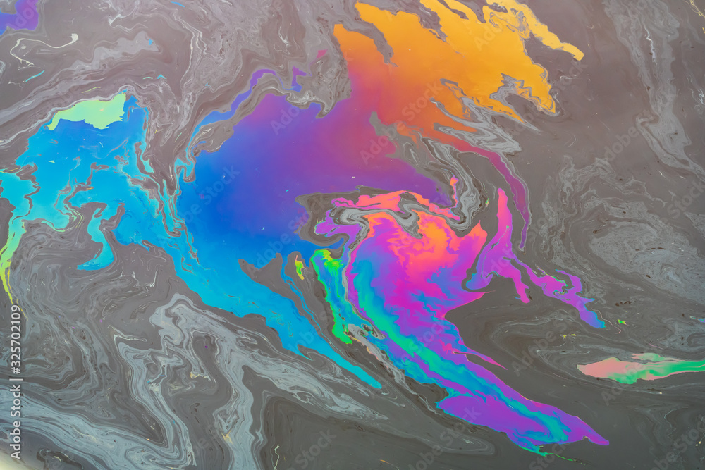 Pollution from a colored oil stain on the water surface