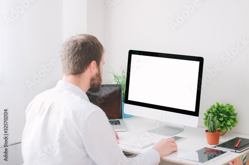Business man using computer with blank screen at home