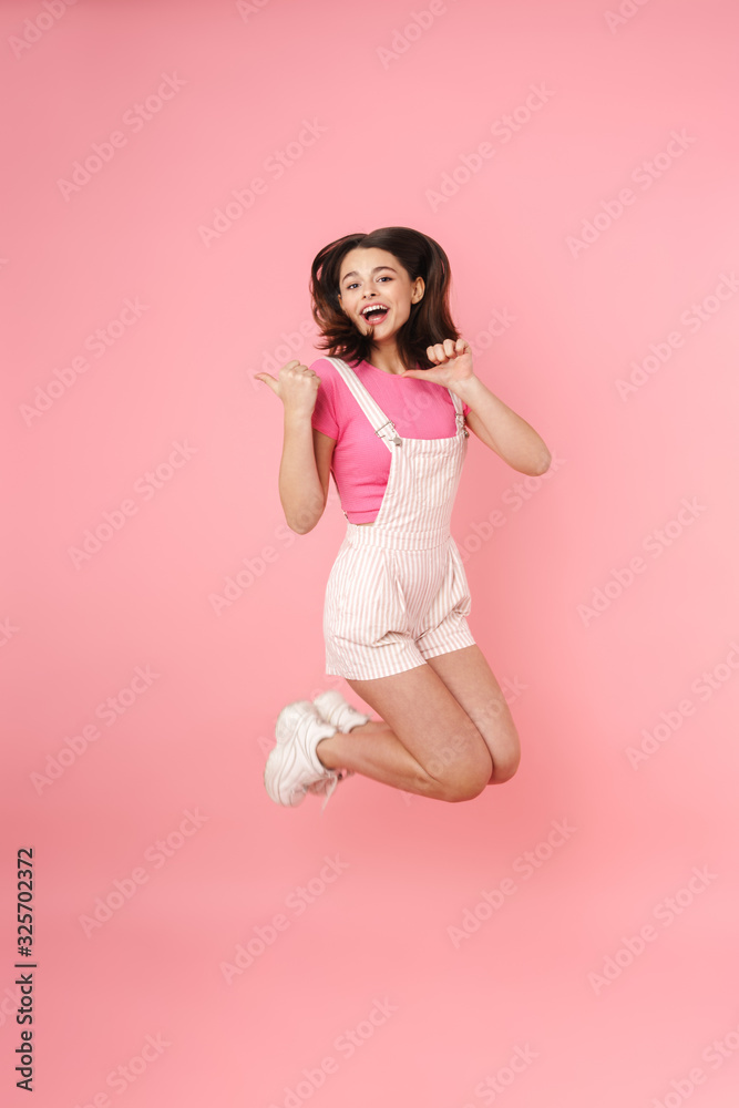 Full length of a pretty excited young teenage girl jumping Full length of a pretty excited young teenage girl jumping